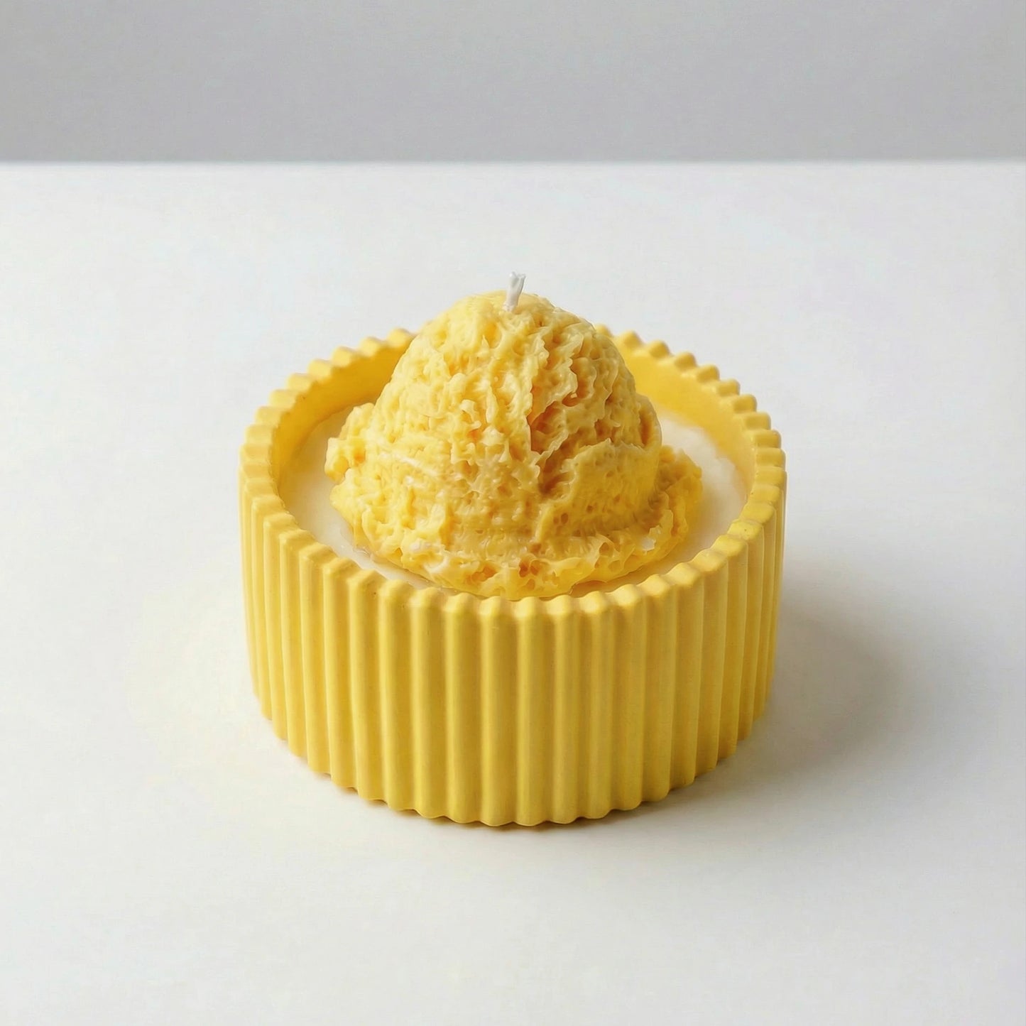 Yellow textured ice cream candle on a white background
